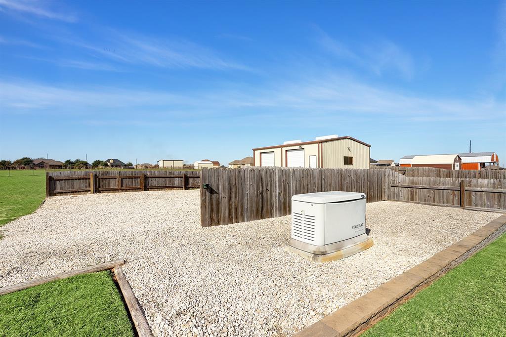 Side yard with a simple rock area for parking trailers or equipment.