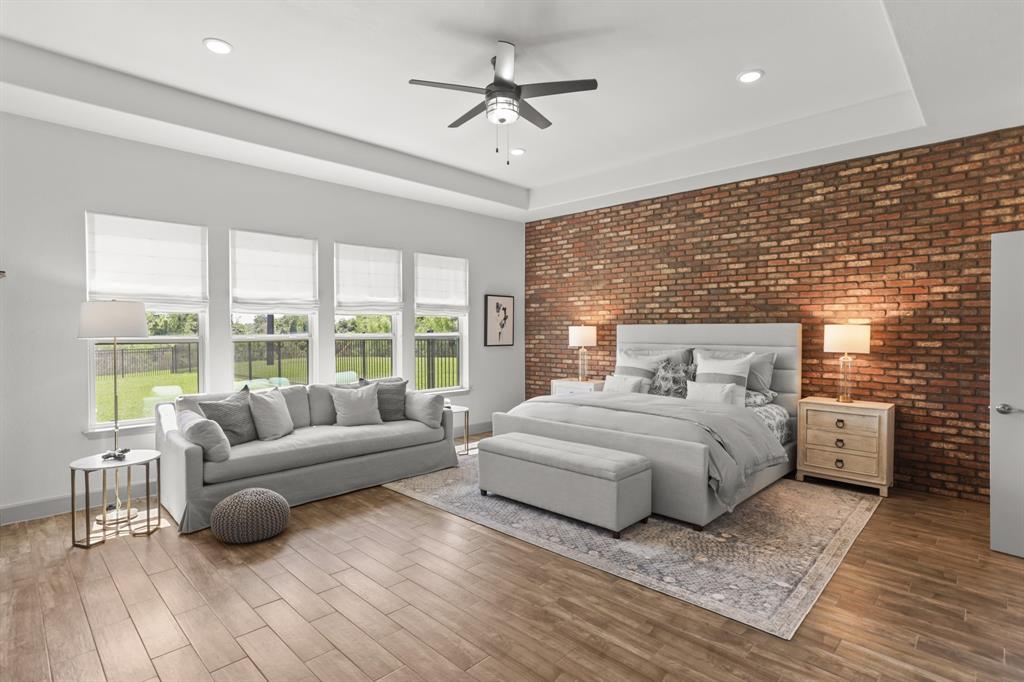 Incredibly Spacious Primary Bedroom, with a Brick wall to make the room feel even more spacious and homey... you will find it is real brick, not painted, and not vinyl