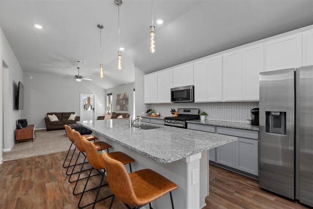 View into the Kitchen from the Entry/Dining Area.  Large Island with Plenty of Room for 4 Bar Stools.  Opens into Living Area.