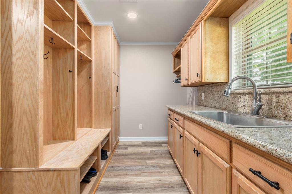 Large laundry/mud room with granite counters, sink and tons of storage. Ample room for an extra refrigerator or freezer. The organizer space efficiently stores jackets, backpacks, footwear and umbrellas and more ensuring a tidy and organized home.