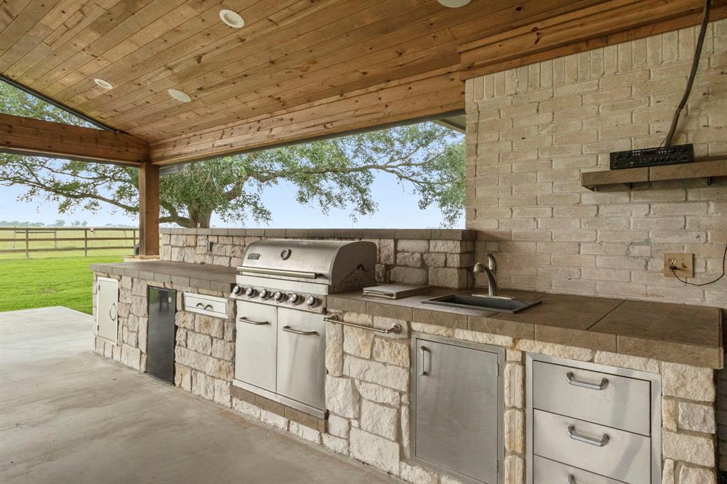 Fully equipped outdoor kitchen, complete with a grill, fridge, and ample counter space offers the perfect setting for al fresco dining and entertaining.