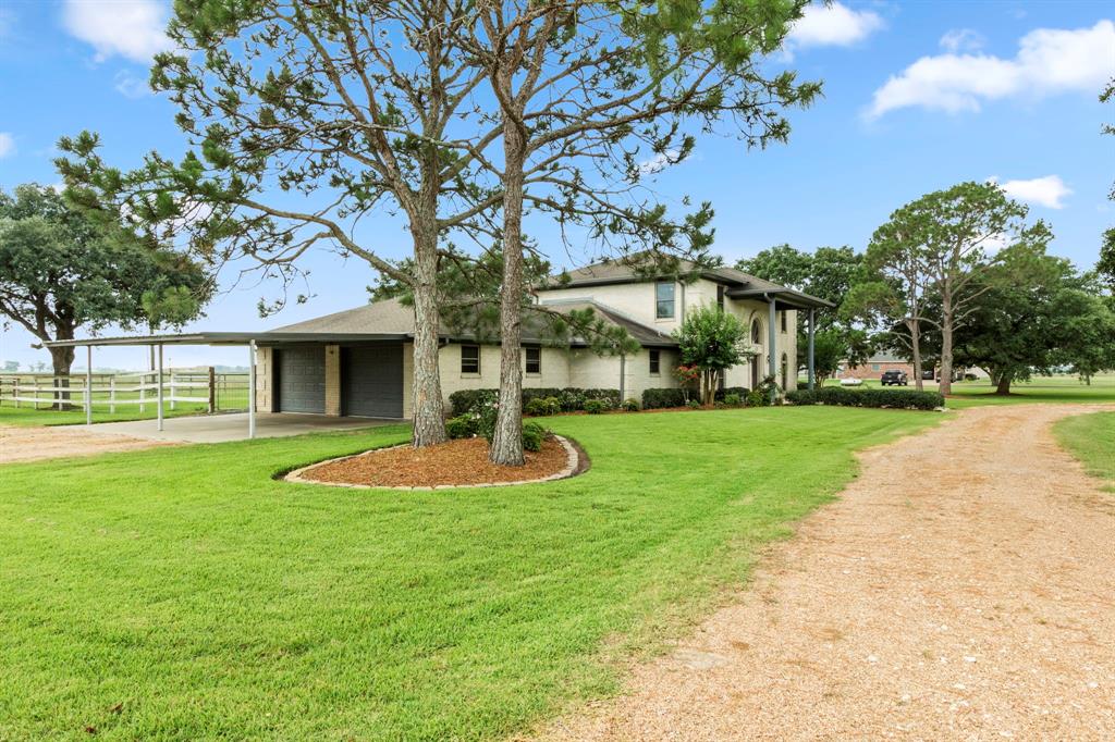 Oversized carport shades the driveway into the oversized garage.