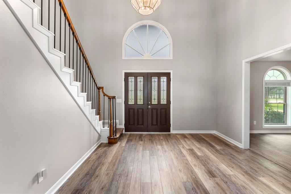 Impressive welcoming and grand scale foyer to greet your guests. To the right is the formal dining area. Note the NEW neutral paint and NEW wood look tile that is featured throughout this stunning home.