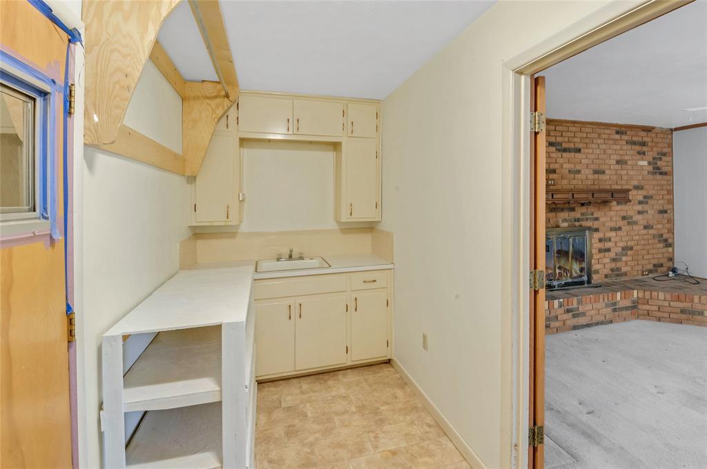 The laundry room, located between the den and double garage, has a double sink at one end.