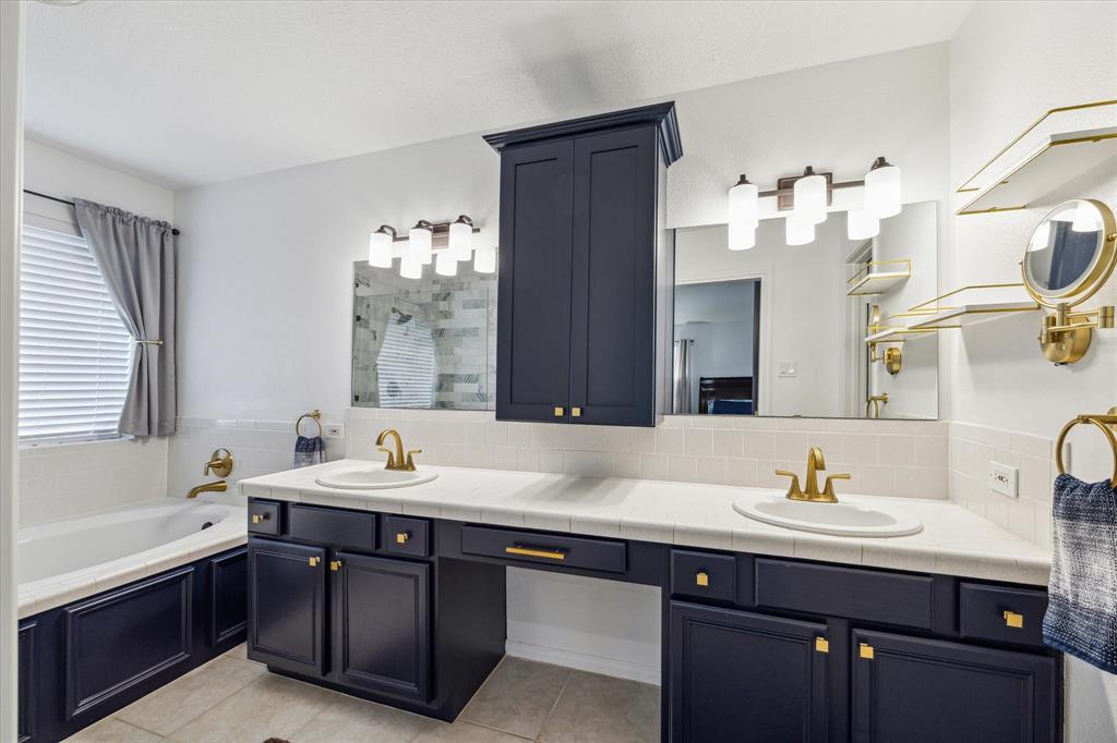 Primary bath with double sinks and vanity area. Updated fixtures.