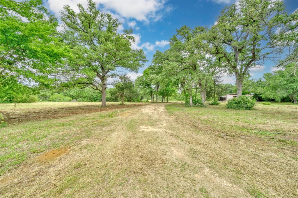 Endless possibilities with this 14± acres located in Burleson County!  As you enter onto the property, you're greeted by a tranquil setting, with a mix of wooded areas and open clearings. The front portion of the land is thoughtfully cleared, providing an ideal space for recreational activities or the construction of your dream home.  Enjoy the large pond, cleared lanes running on the backside of property, and spacious barn.  Whether you are looking for recreational, hunting, cattle, or building your forever home this is one you do not want to miss.  Convenient location approx. 35 minutes to BCS, 1 hour 20 min to Waco, and 1.5 hour to Austin.  Water and electricity are available at the road.  This won't last long.  Come take a look today!