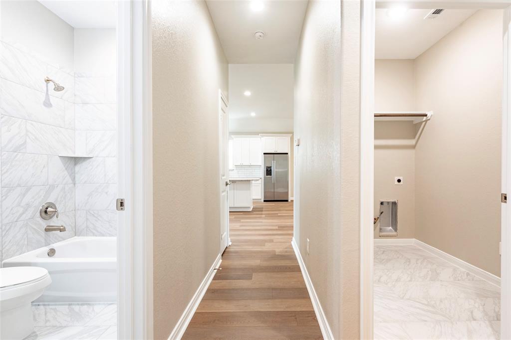 Hallway view showing hall bath and utility room