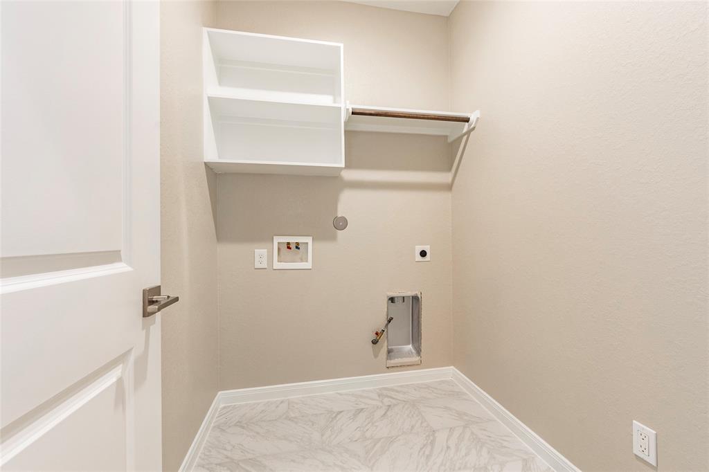 Utility room includes shelving and gas/electric dryer hookups