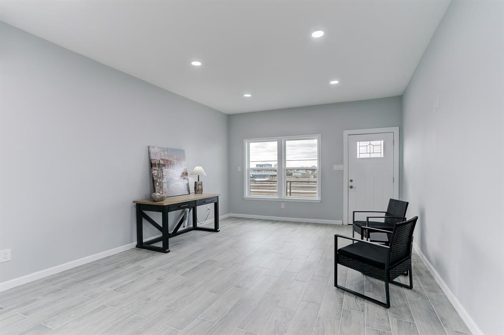 VIEW OF THE DEN AND ENTRY.  NEUTRAL, LOW MAINTENANCE TILE FLOORS FLOW THROUGHOUT THE ENTIRE HOME.