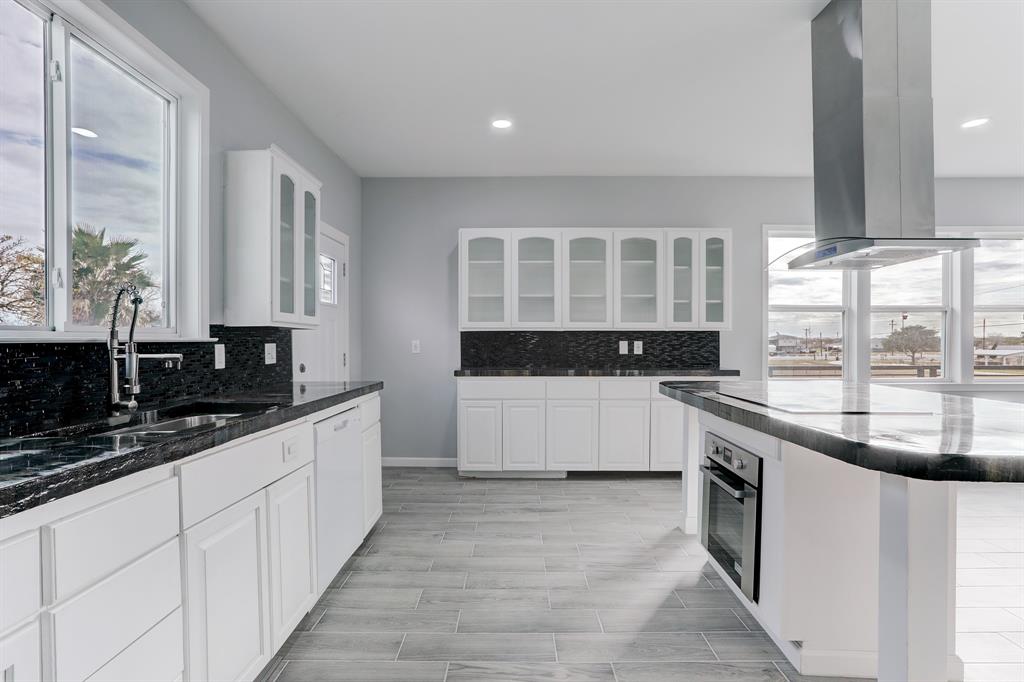 VIEW OF THE KITCHEN AND ATRIUM DOOR LEADING TO THE REAR BALCONY THAT WRAPS AROUND THE ENTIRE FIRST LEVEL.