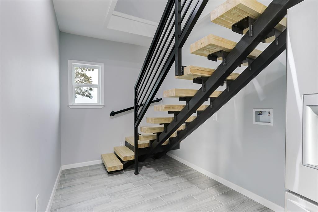 ACCESS TO THE 2ND LEVEL VIA A STRIKING HAND-CRAFTED STEEL AND WOOD FLOATING STAIRCASE.