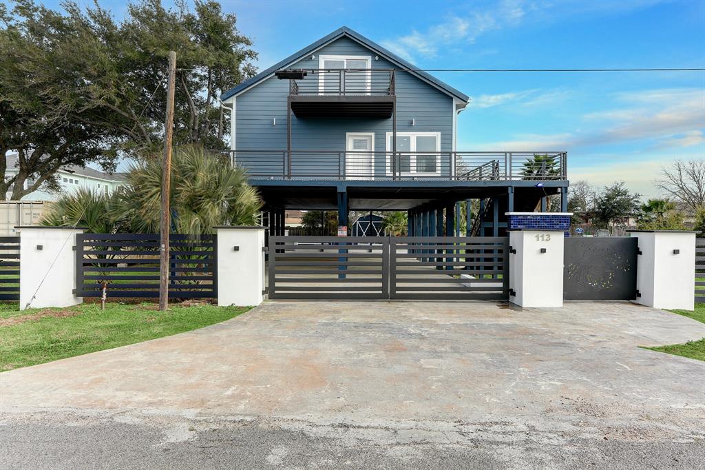 FRONT ELEVATION WITH DRIVEWAY GATE CREATES PRIVACY WHICH IS IDEAL ON THE BAY.