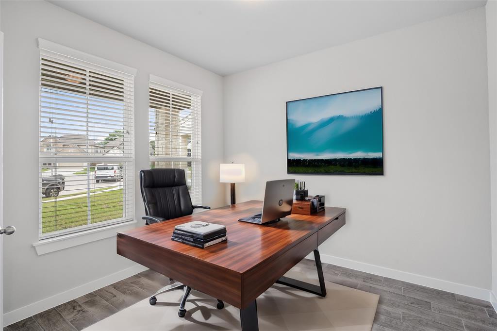 Quietly nestled in front of the home is the handsome home office. Featuring gorgeous flooring, custom paint and large windows.