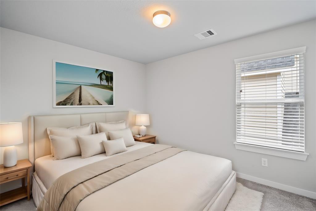 Secondary bedroom features plush carpet, custom paint and a large window.