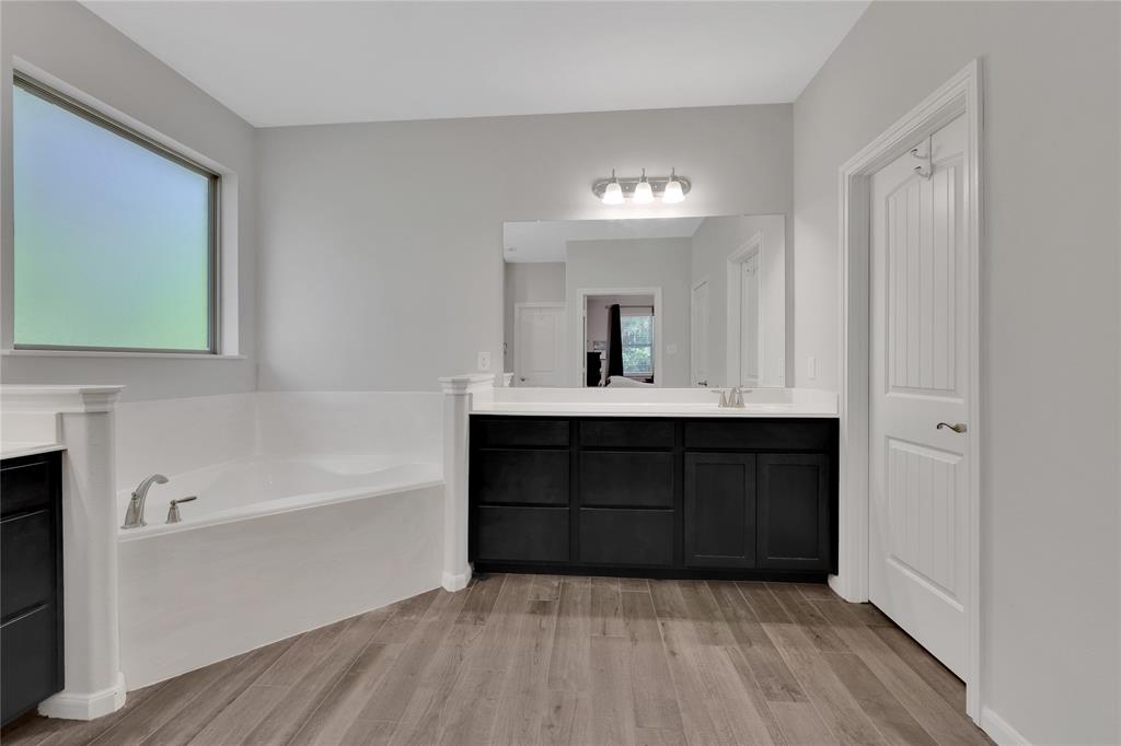 The primary bathroom has dual sinks, corner soaking tub and two walk in closets