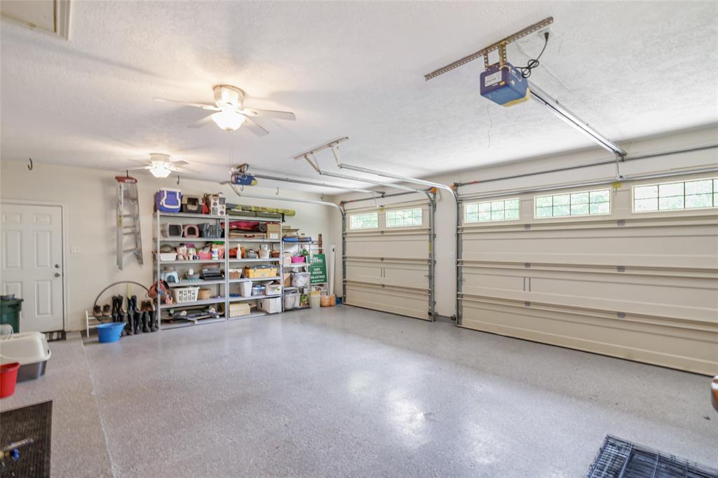 The expoxy garage flooring is spacious with plenty of storage and boasts higher ceilings for a tractor.