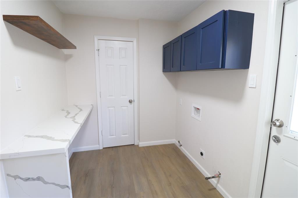 In house laundry room with quartz countertops.