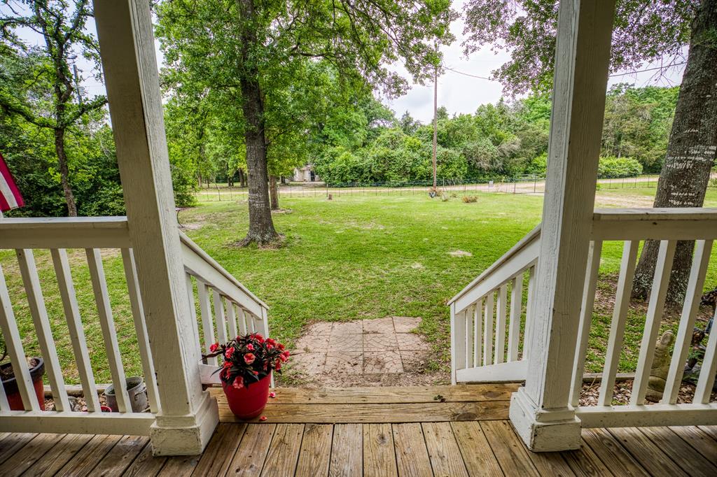 The stairs lead to the front yard under the beautiful trees.