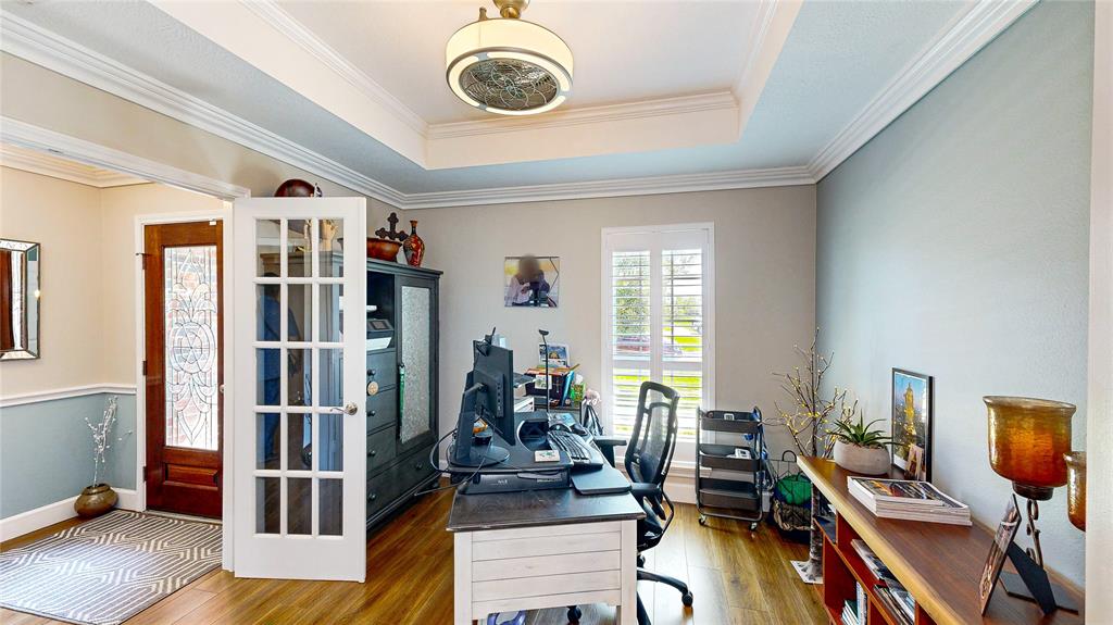 Designated Office/Study. So many great details add to this rooms charm. Recessed ceiling, crown molding, Plantation Shutters, and glass French Doors,