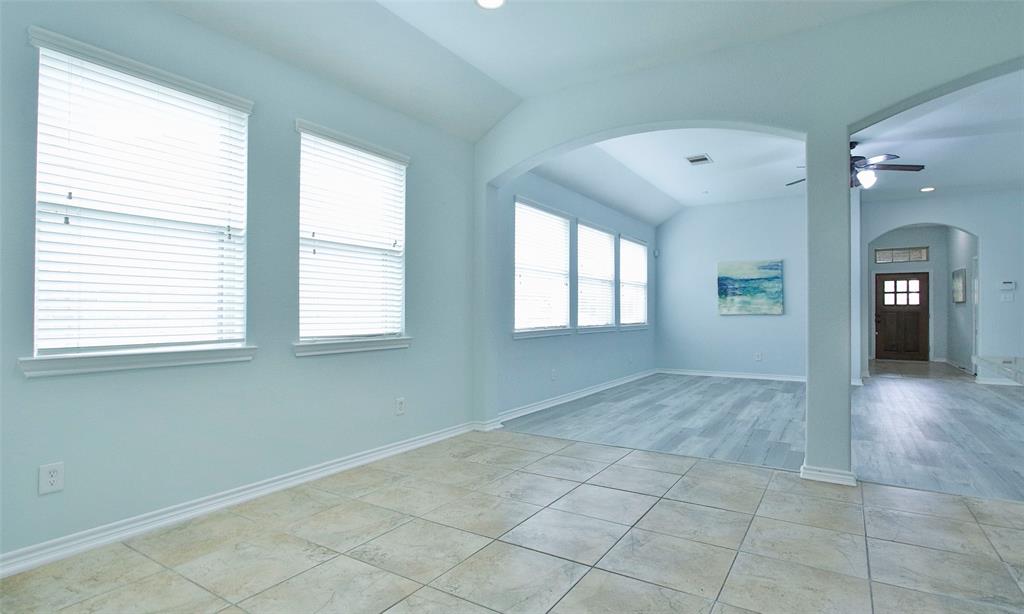 View from the dining area to island kitchen with granite counter tops and lots of cabinets for storage.