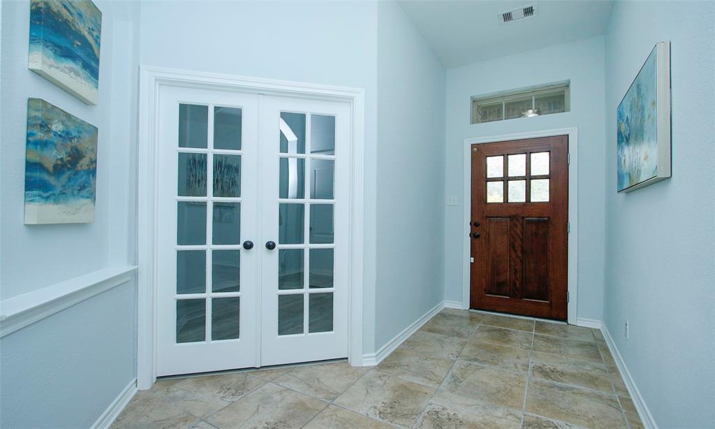 Welcome home through beautiful landscape and covered front porch with gleaming wood front door.