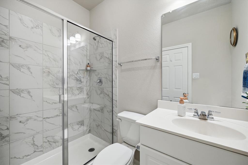 THIRD BEDROOM\'S EN SUITE BATH OFFERS A GLASS-ENCLOSED SHOWER.