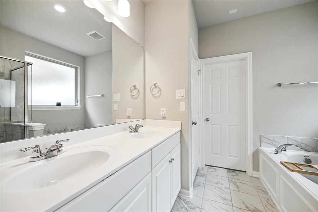 THE MASTER BATH FEATURES DOUBLE SINKS, TILE FLOOR, WATER CLOSET, AND A SPACIOUS WALK-IN CLOSET WITH 9\'X9\' DIMENSIONS.