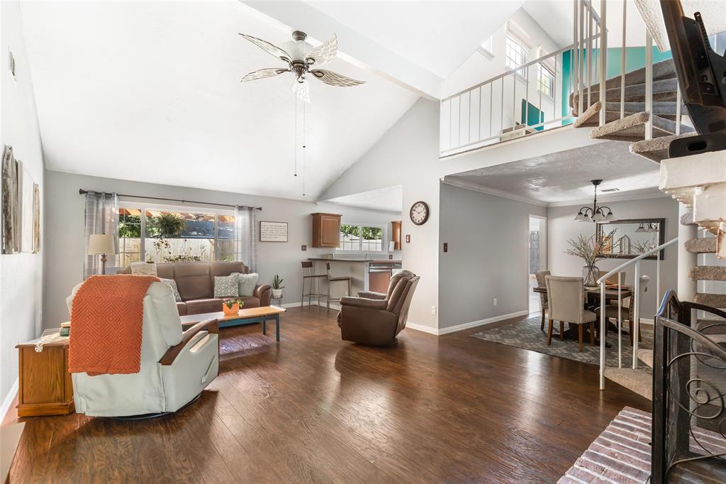 Living room with high ceiling, loft, and breakfast bar