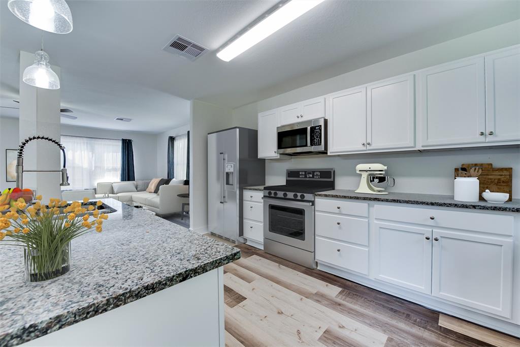 Off the kitchen, a convenient laundry room (behind this view) keeps the home running smoothly. (Some virtual staging may be present).