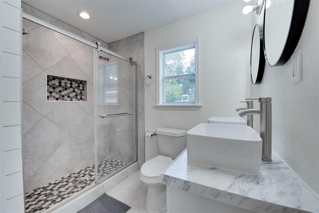 After busy days, unwind in the master bath\'s dual-sink vanity and glass door shower. (Some virtual staging may be present)