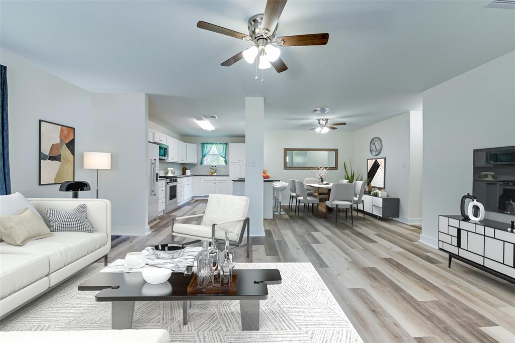 The open concept living and dining room boast vinyl floors, a ceiling fan and an airy, light-filled space perfect for entertaining. Just beyond, the kitchen features granite counters, stainless appliances and custom cabinetry. (Some virtual staging may be present)