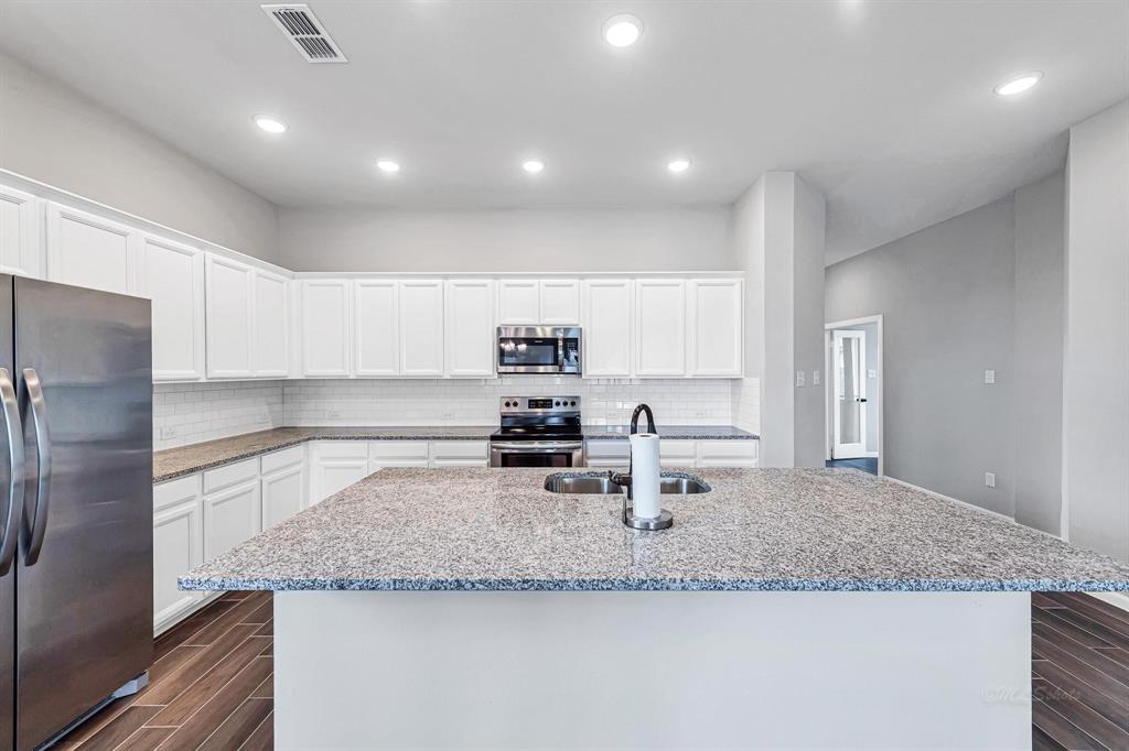 Take a look at the many white cabinets for storage and the endless countertop space available in the kitchen.