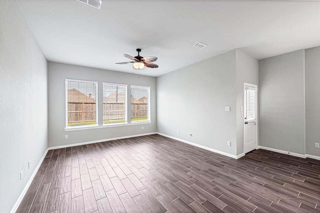 The home features gray and white paint throughout, creating a modern and cohesive aesthetic. With no carpet, the same wood-like tile flooring is not only stylish but also easy to maintain. Additionally, every room is equipped with ceiling fans for added comfort and functionality.