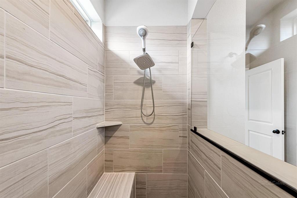 Here\'s another view to showcase the size and spaciousness of this shower. The tile work is beautifully done, matching the rest of the home with its gray and white tones.