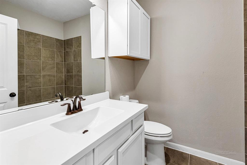 The home offers 3 full bathrooms. This particular bathroom is conveniently located near the guest rooms and features a shower-tub combo, adding practicality and convenience for guests.