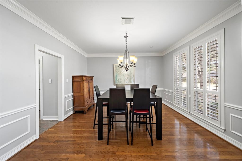 The bright dining area showcases wood flooring, plantation shutters, and quick access to the kitchen and breakfast areas.