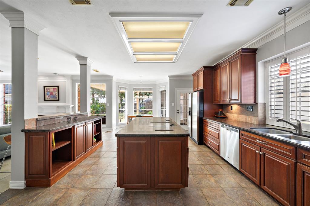 This well-appointed kitchen features a granite-topped island with a cooktop and beverage refrigerator, plus a convenient layout that provides easy access to the living and breakfast areas.