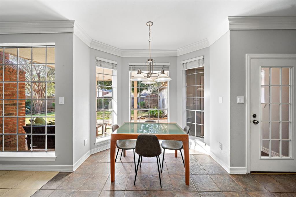 Enjoy your morning coffee in this sunlit breakfast nook, where every glance out the window offers a view of the lush backyard.