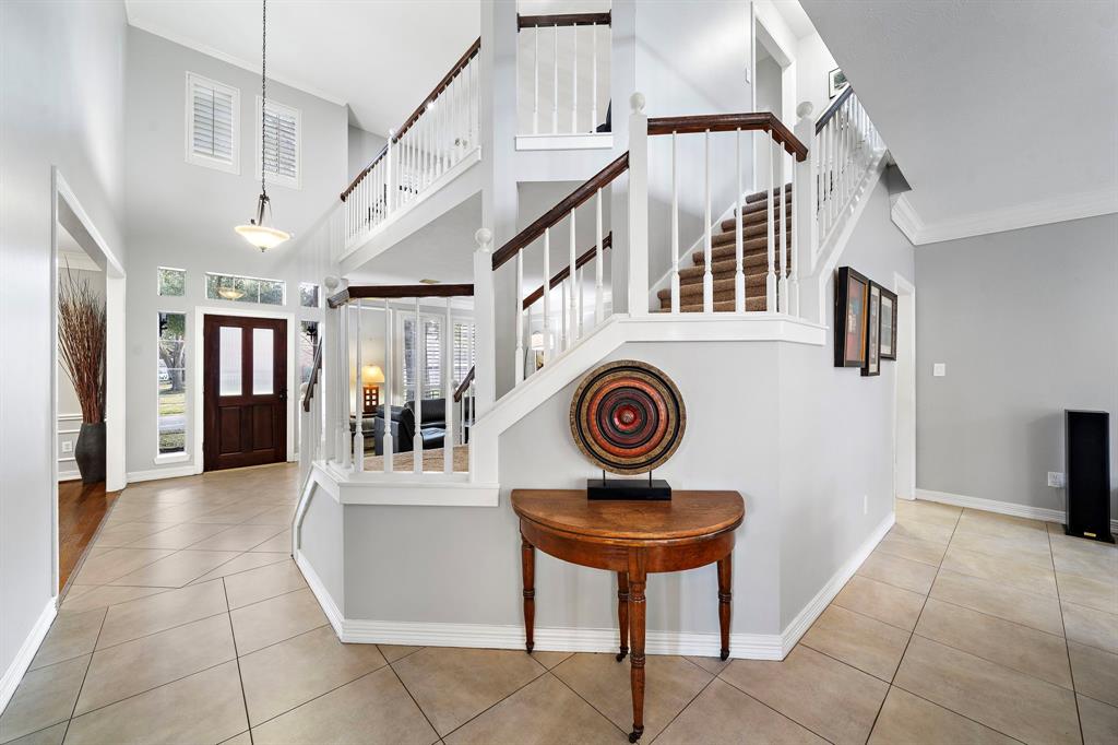 Featuring a carpeted staircase as its centerpiece, this hall effortlessly lead guests to the living area, formal dining, and the kitchen.