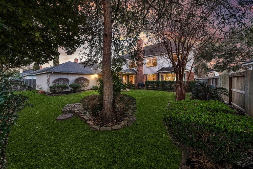 From the manicured landscaping and tall mature trees, every detail of the fully-fenced backyard is a verdant retreat.