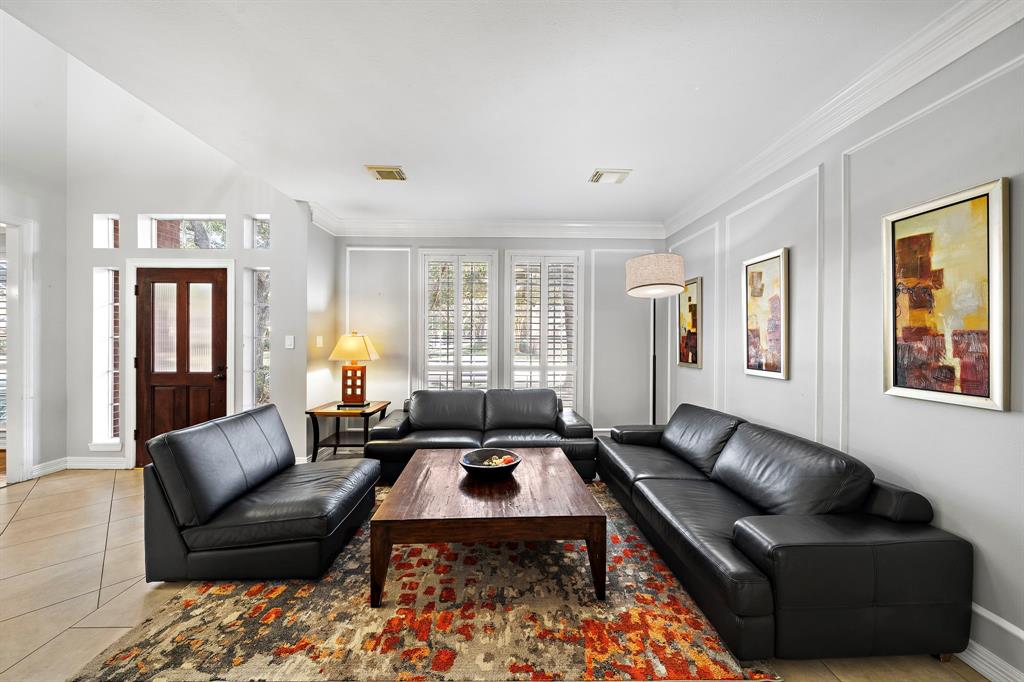 Optimally laid out for entertaining, the expansive den is dressed with tile floors and tall windows offering natural light. Its bright and airy layout offers generous accommodations for seating.