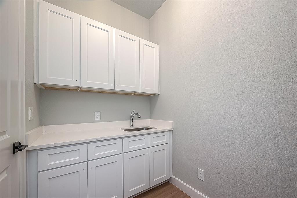 Laundry Room with Upper and Lower Cabinets and Laundry Sink