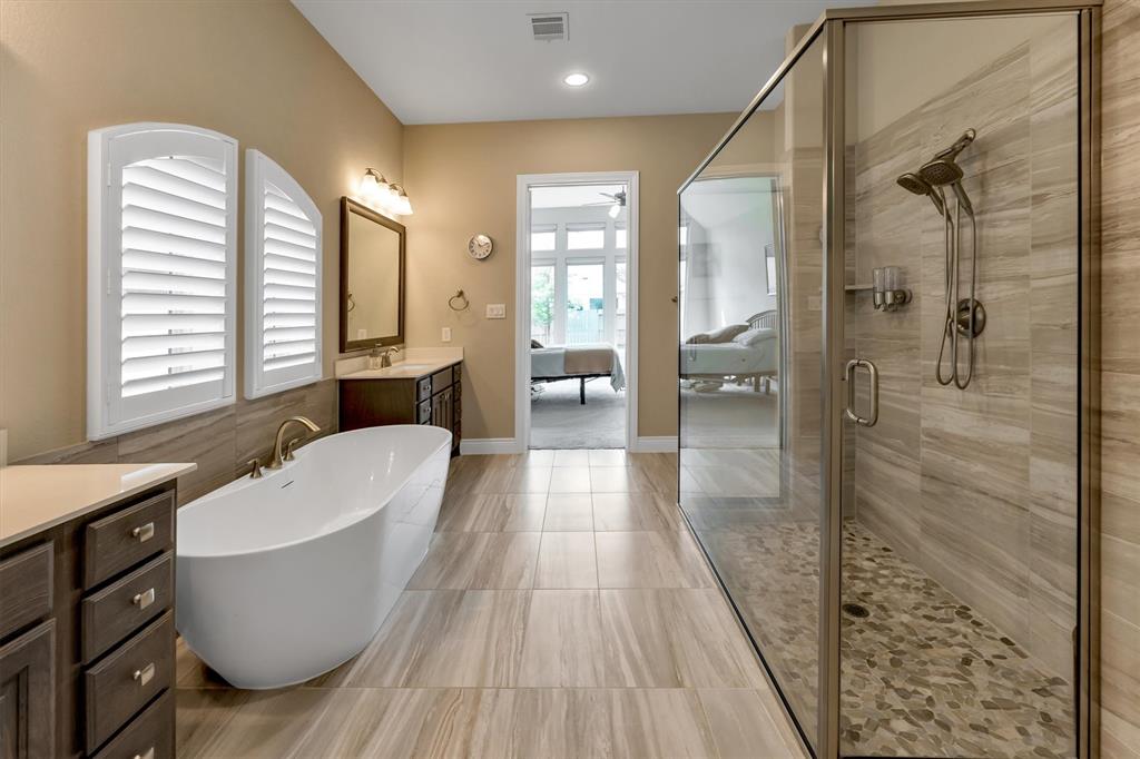 Primary bathroom w/ dual vanities, a soaking tub, and a huge walkin shower