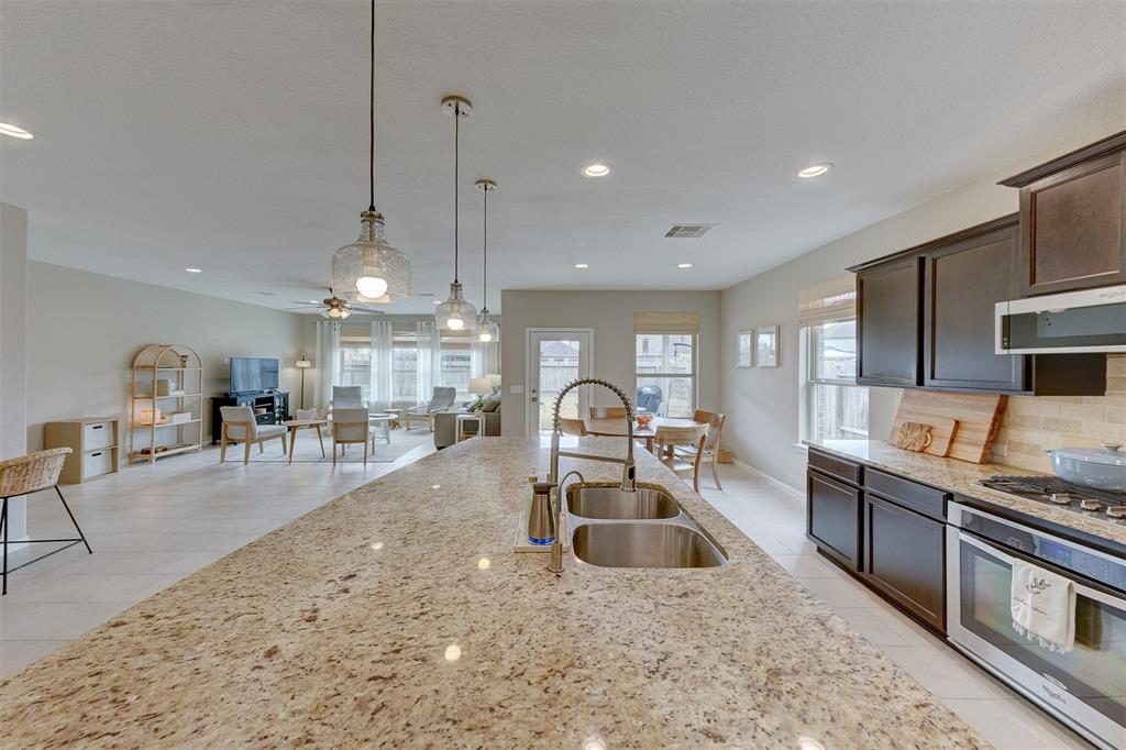 Granite counters and stainless under-mount sink are showcased here.