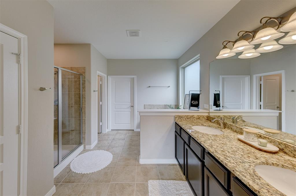 The luxurious primary bath has a double vanity, soaking tub, and an oversized shower.