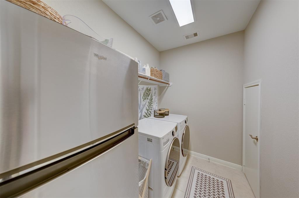 Large walk in laundry room with plenty of shelving for supply storage, as well as a mini-closet for excess storage