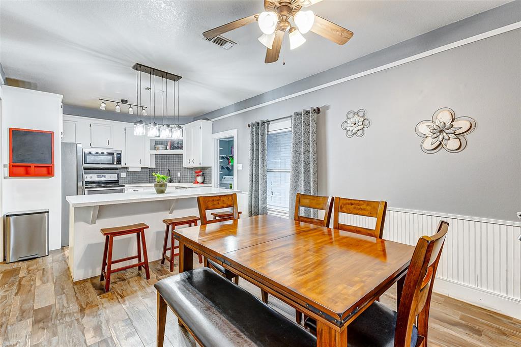 Savor every mealtime moment in this open-concept dining room, seamlessly flowing into the chic kitchen, where gatherings are enhanced by stylish design and effortless elegance.