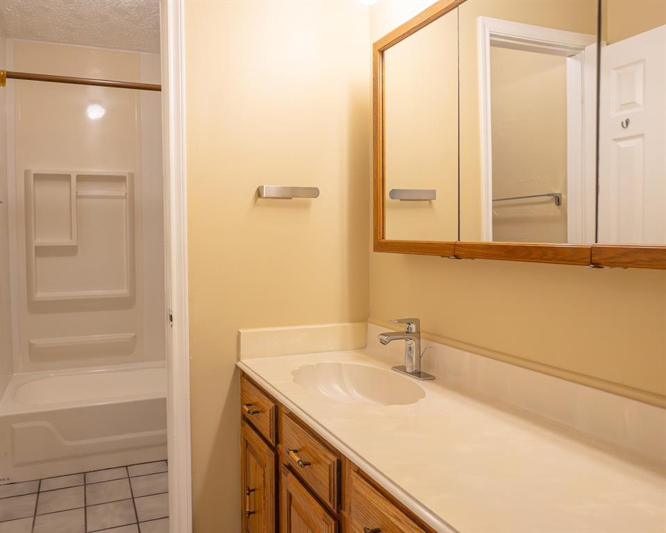 Guest bach has lots of cabinetry for storage and tub/shower combination