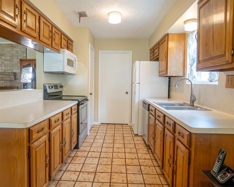 Kitchen is fully equipped with electric range, refrigerator, double sink, microwave and dishwasher