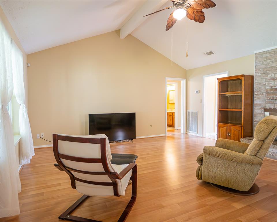 Light and bright! Living room features vaulted ceiling and wood burning brick fireplace